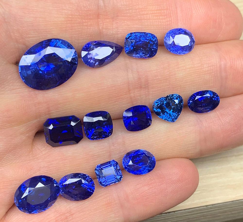 Suites of classic blue sapphires, displayed on a hand, loose